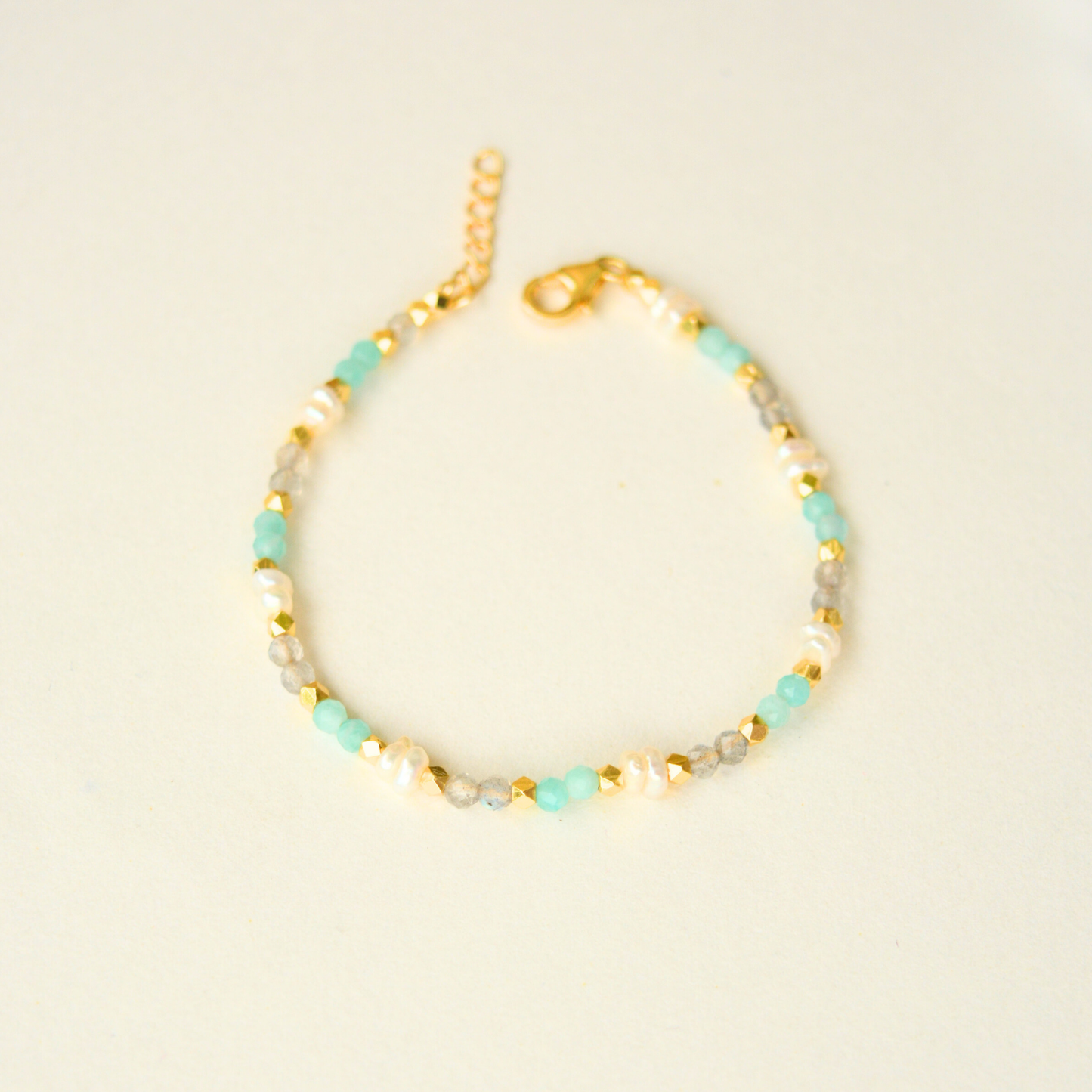 Adjustable beaded bracelet with faceted pastel gemstones and gold plating