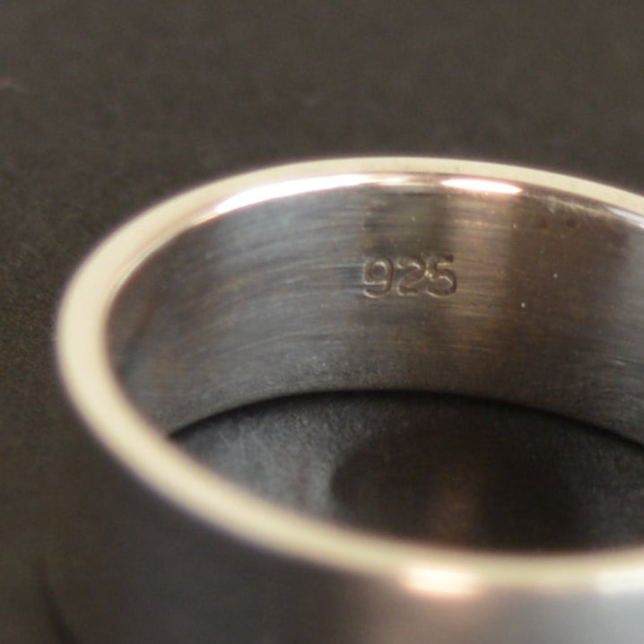 Silver ring on a black surface