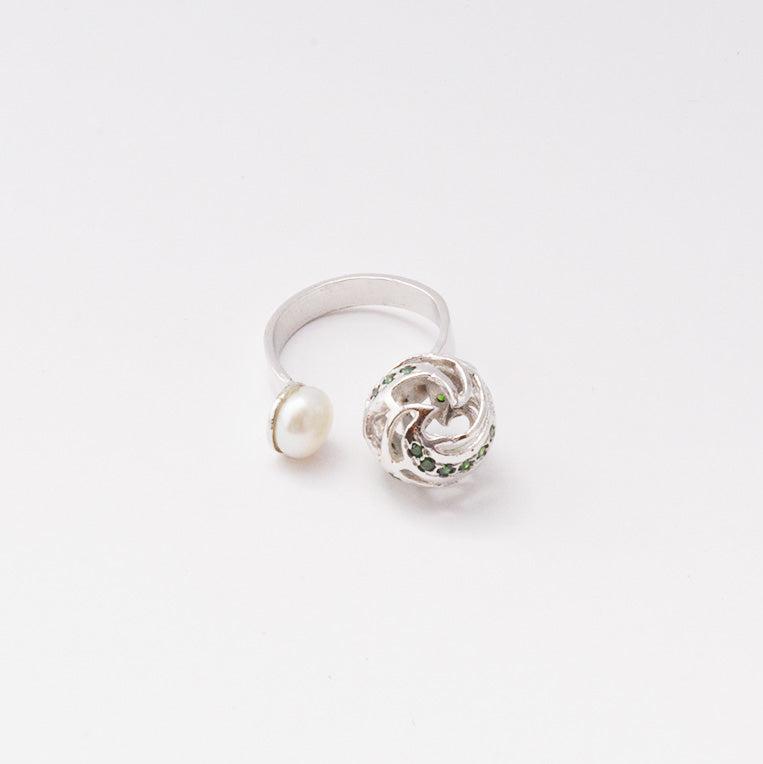 A sophisticated silver ring featuring a lustrous, high-quality pearl that rests gracefully on a sleek, polished band, isolated on a white background.