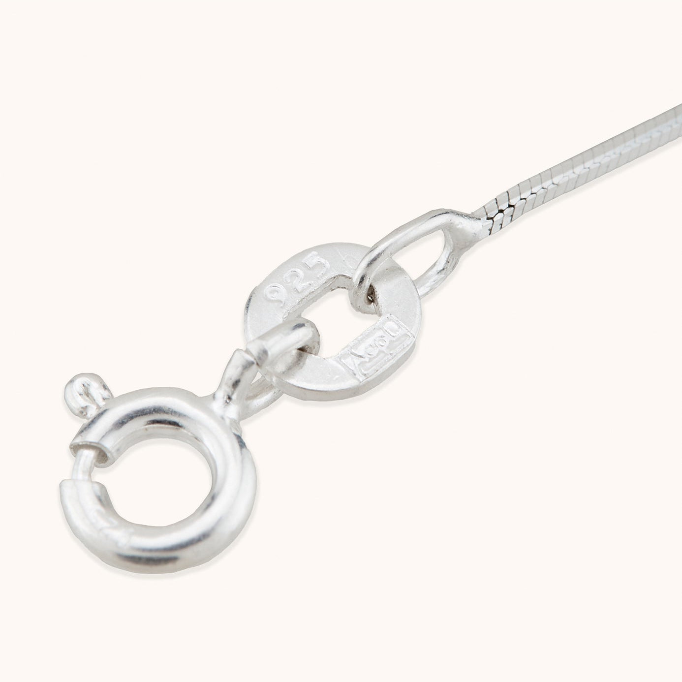 Close-up macro detail of a 925 sterling silver hallmark on a ring clasp and sleek stride anklet link.