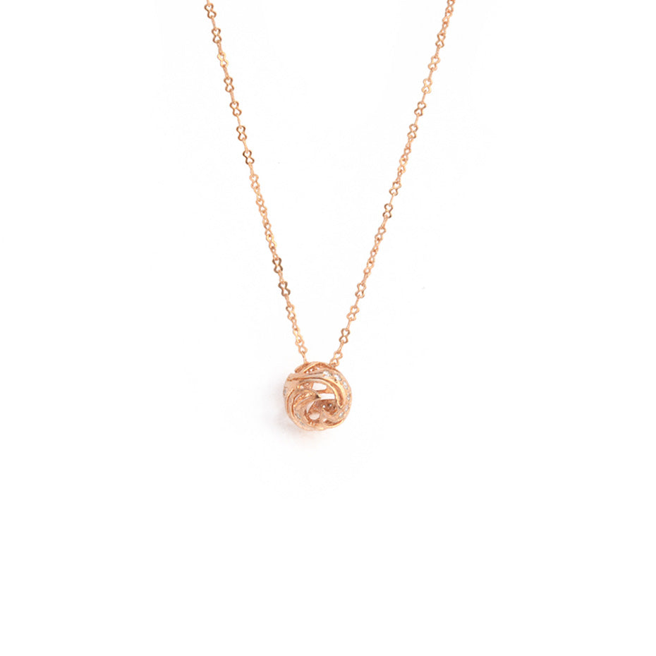 A sophisticated, high-shine brass pendant featuring a fluid, wave-inspired sculptural design, suspended on a delicate matching chain against a white background.