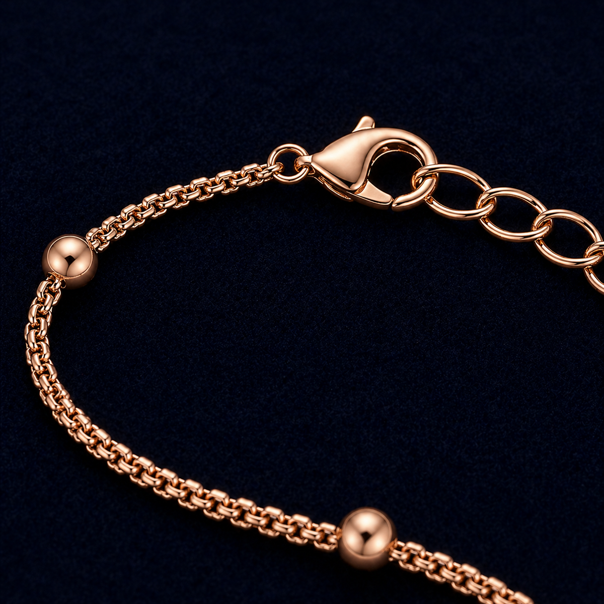 A close-up detail shot of the Subtle Circles bracelet highlighting the high-polish rose gold finish, the textured link chain, and the secure lobster clasp with an adjustable extension chain.