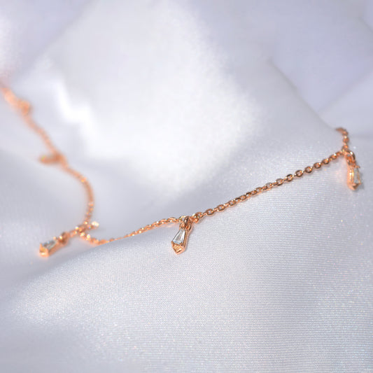 A stylish, airy rose gold necklace laid out on a soft, textured surface, emphasizing its light and versatile design perfect for everyday luxury.