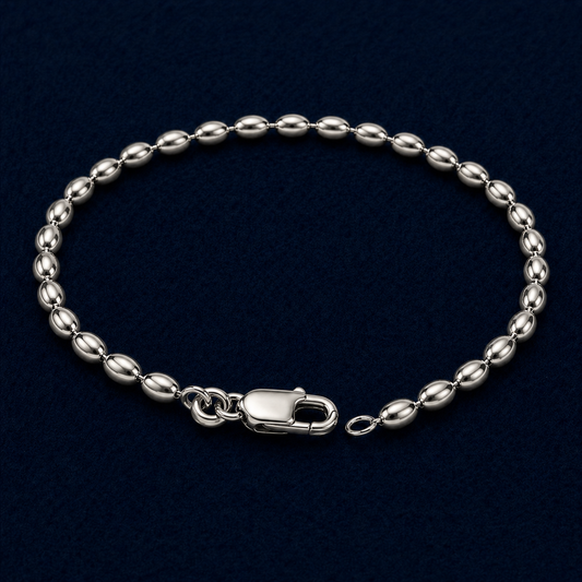 A full studio shot of the handcrafted Effortless Shine anklet in 925 sterling silver, featuring a rhythmic oval link chain design on a dark navy background.