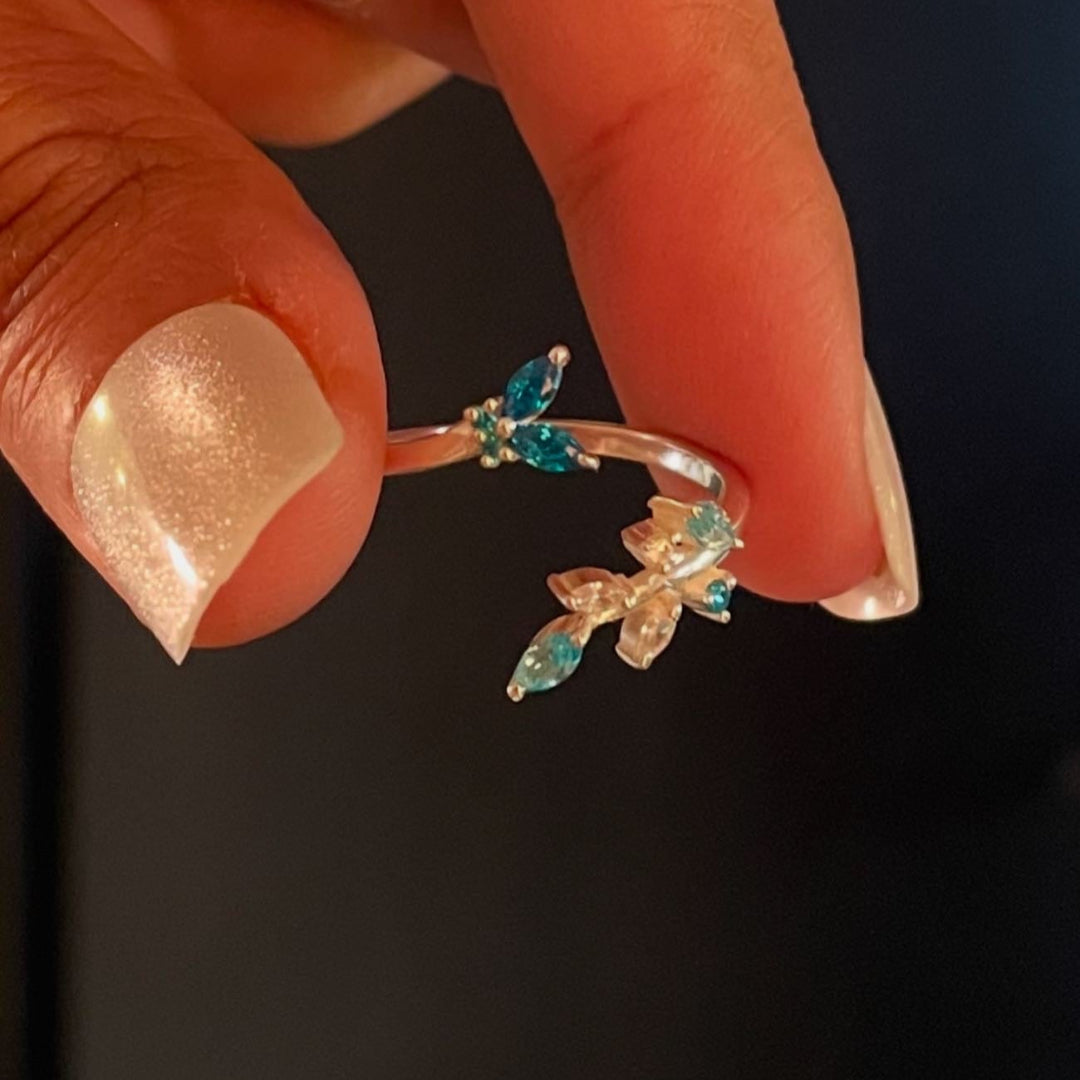 Detail shot of a sterling silver butterfly ring on a model's finger, showcasing the delicate nature-inspired engraving.