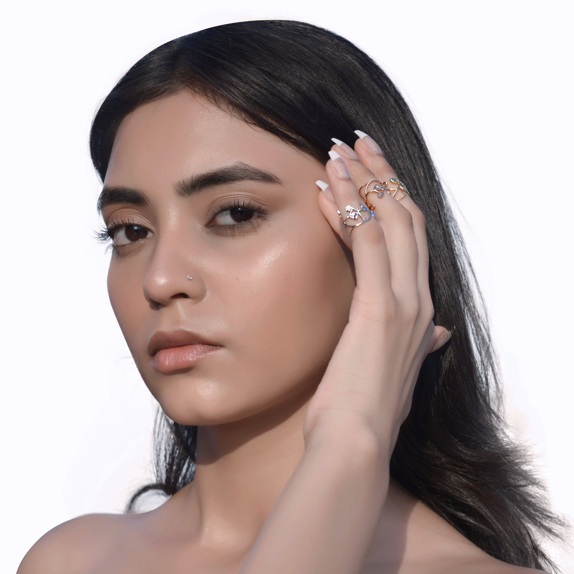 A model displaying a variety of thin, metallic midi rings in assorted gold, rose gold, and silver tones, highlighting their stackable design for a modern look.