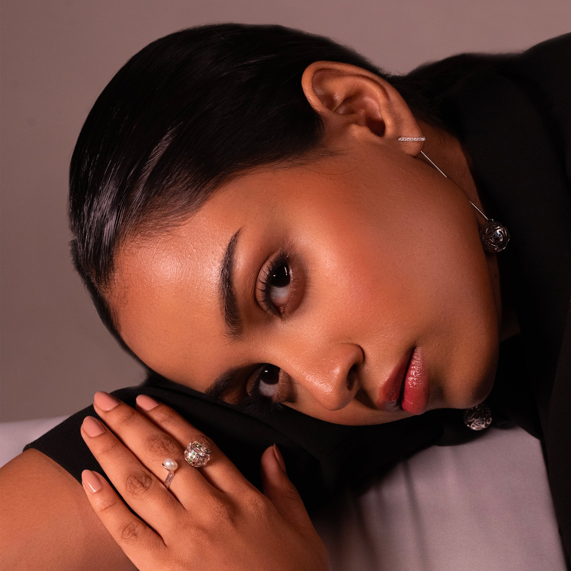 An angled view of a model wearing a modern, polished silver-toned band accented with a single, lustrous pearl, emphasizing its versatile style for both formal and everyday wear.
