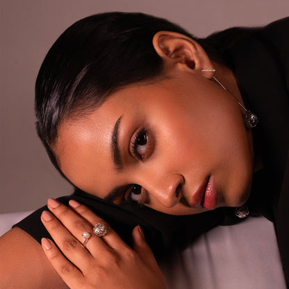 An angled view of a model wearing a modern, polished silver-toned band accented with a single, lustrous pearl, emphasizing its versatile style for both formal and everyday wear.