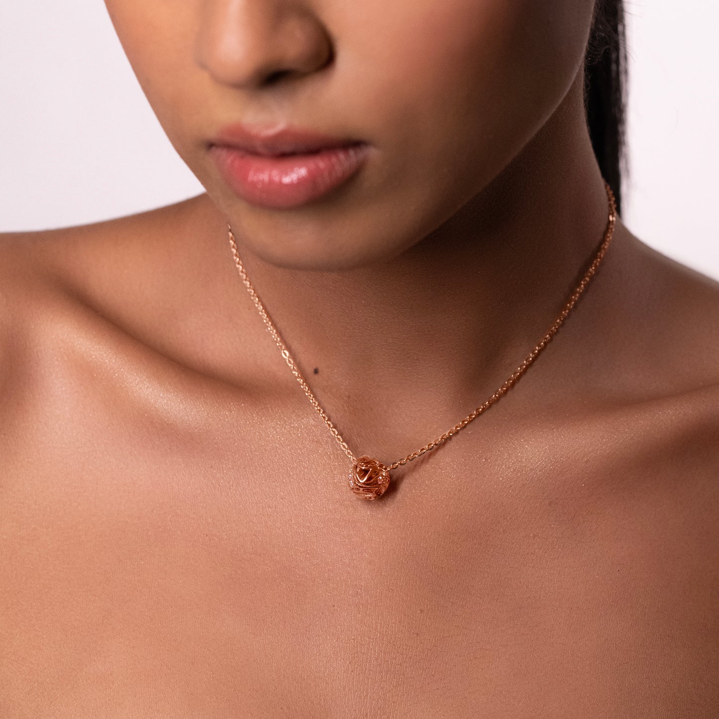 A model wearing a striking, oversized sculptural brass necklace that sits elegantly on the collarbone, creating a modern and artistic silhouette.