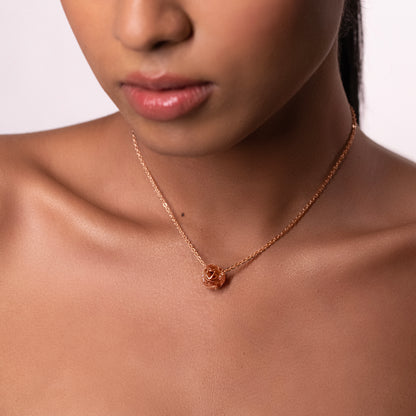 A model wearing a striking, oversized sculptural brass necklace that sits elegantly on the collarbone, creating a modern and artistic silhouette.