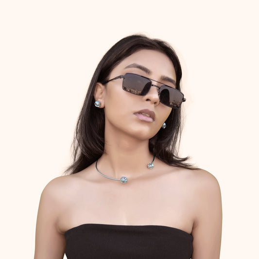 A model wearing round white rhodium statement studs with wave-patterned filigree and colorful sparkling stones, offering a sophisticated and dramatic look.