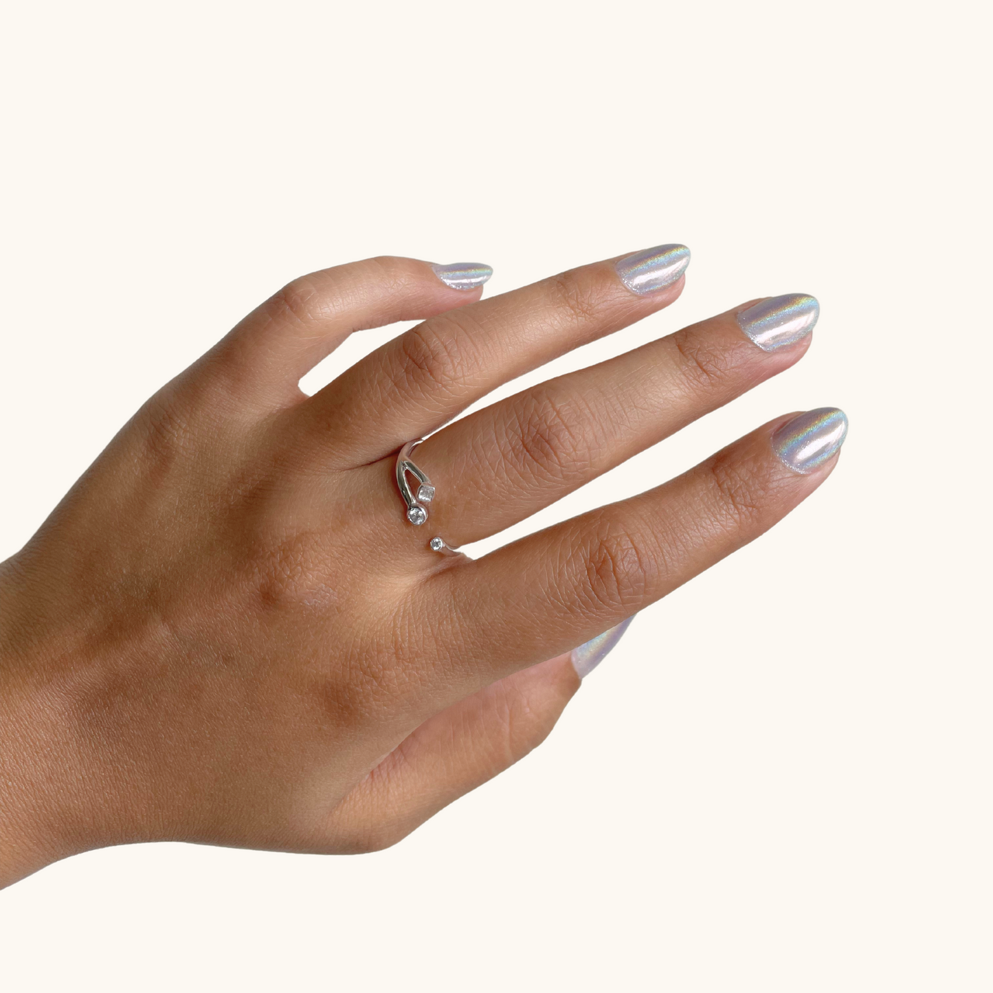 A close-up view of a delicate ring featuring a cluster of sparkling, star-shaped accents that gracefully sit across the finger, showcasing a modern and celestial-inspired aesthetic.