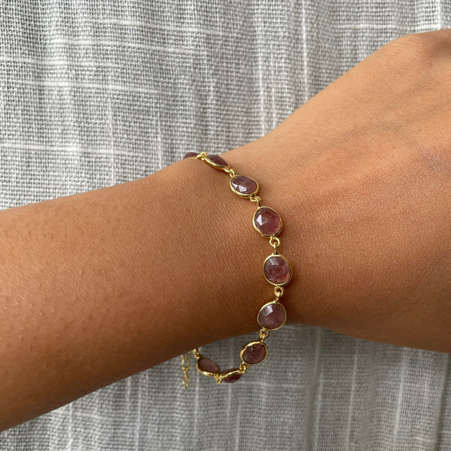 A person wearing a refined silver bracelet with a natural stone accent, styled for a minimalist look.