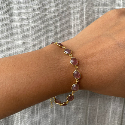 A person wearing a refined silver bracelet with a natural stone accent, styled for a minimalist look.