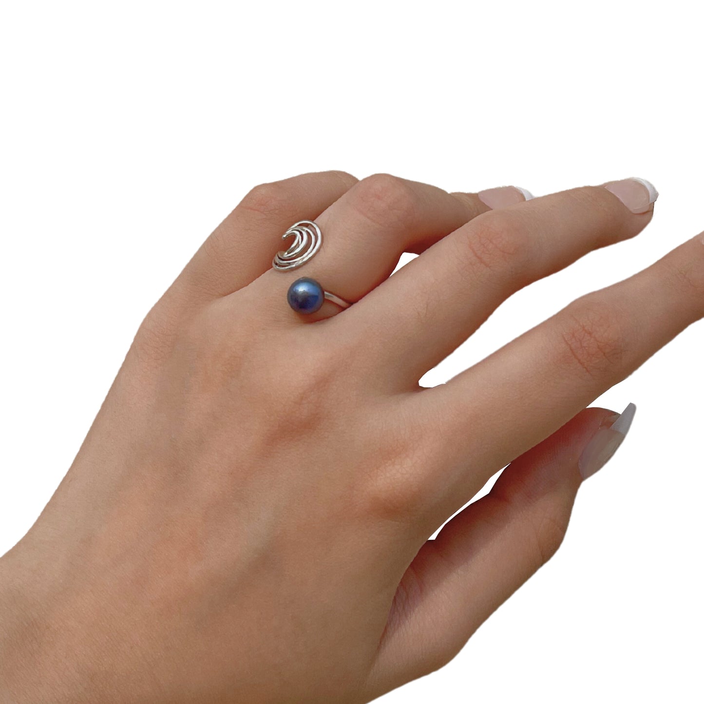 Close-up of a handcrafted 925 sterling silver ring on a finger, showcasing its unique wave-like band and a lustrous blue freshwater pearl.