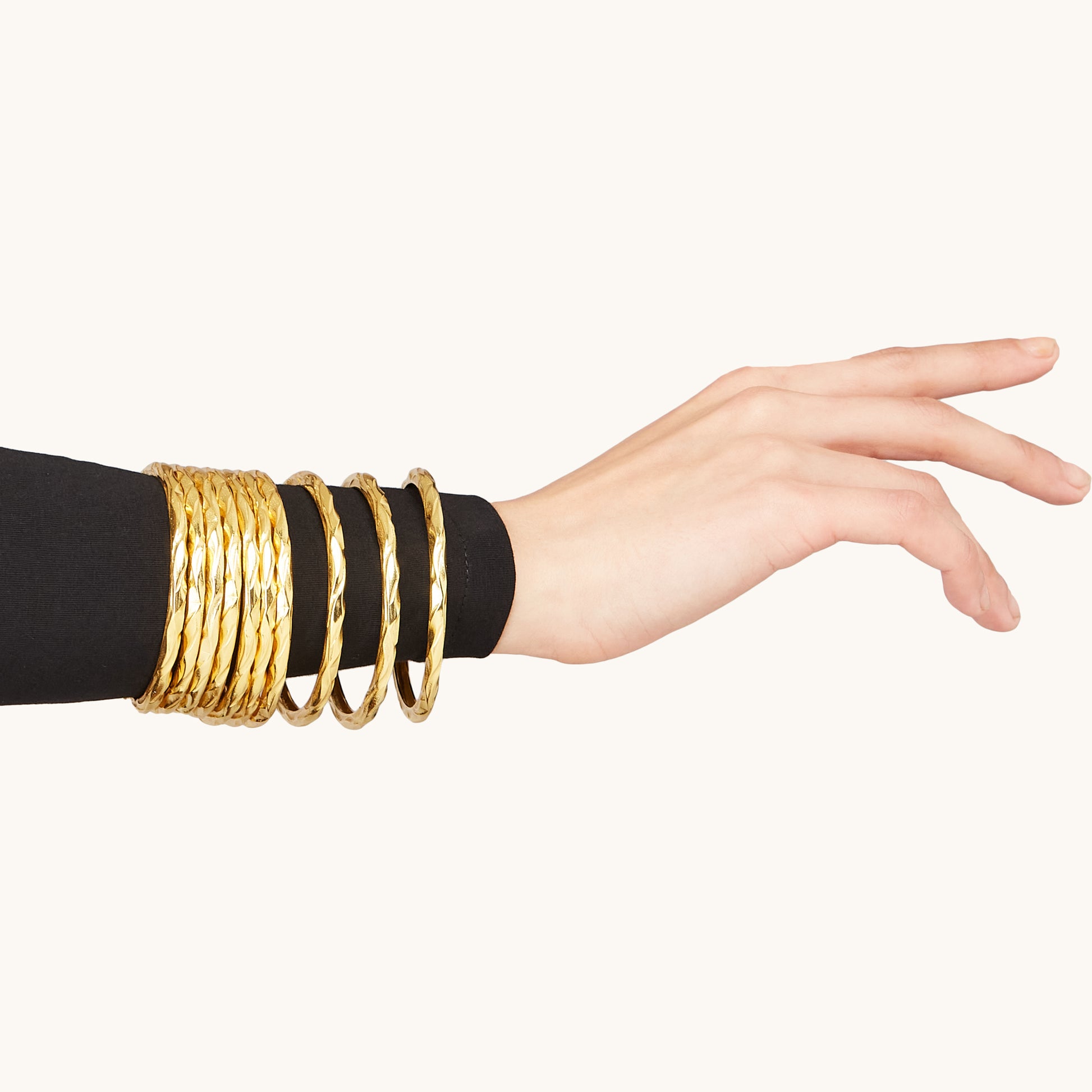A close-up portrait of a woman wearing a minimalist circular metallic bangle on her wrist.