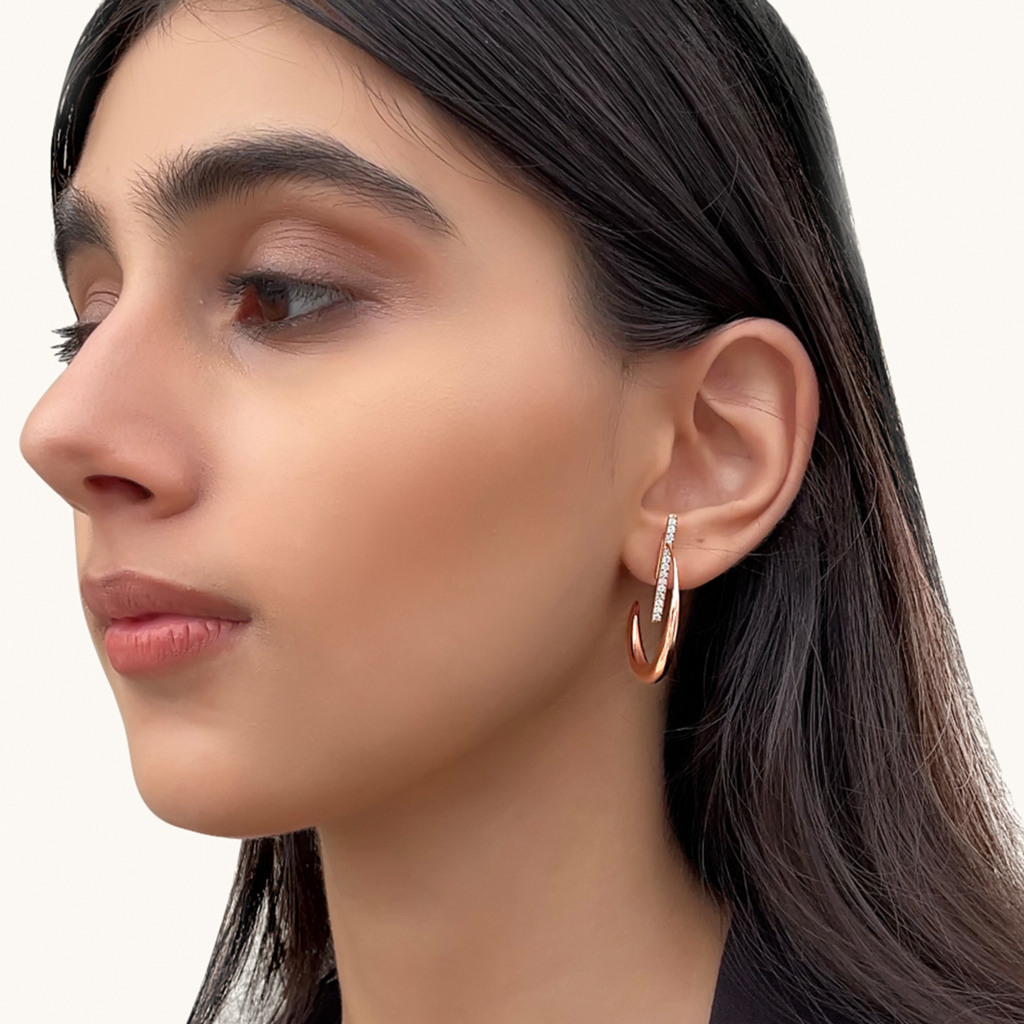 Close-up of a model wearing the La Luna Rose Gold Earrings to show how the crescent moon curves elegantly below the earlobe.