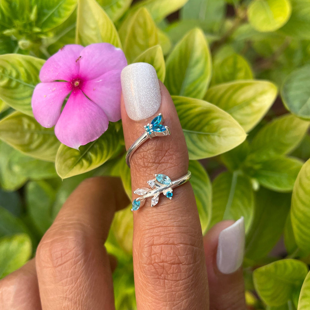 Editorial jewelry shot of a model featuring a convertible silver ring with a butterfly and blossom aesthetic.