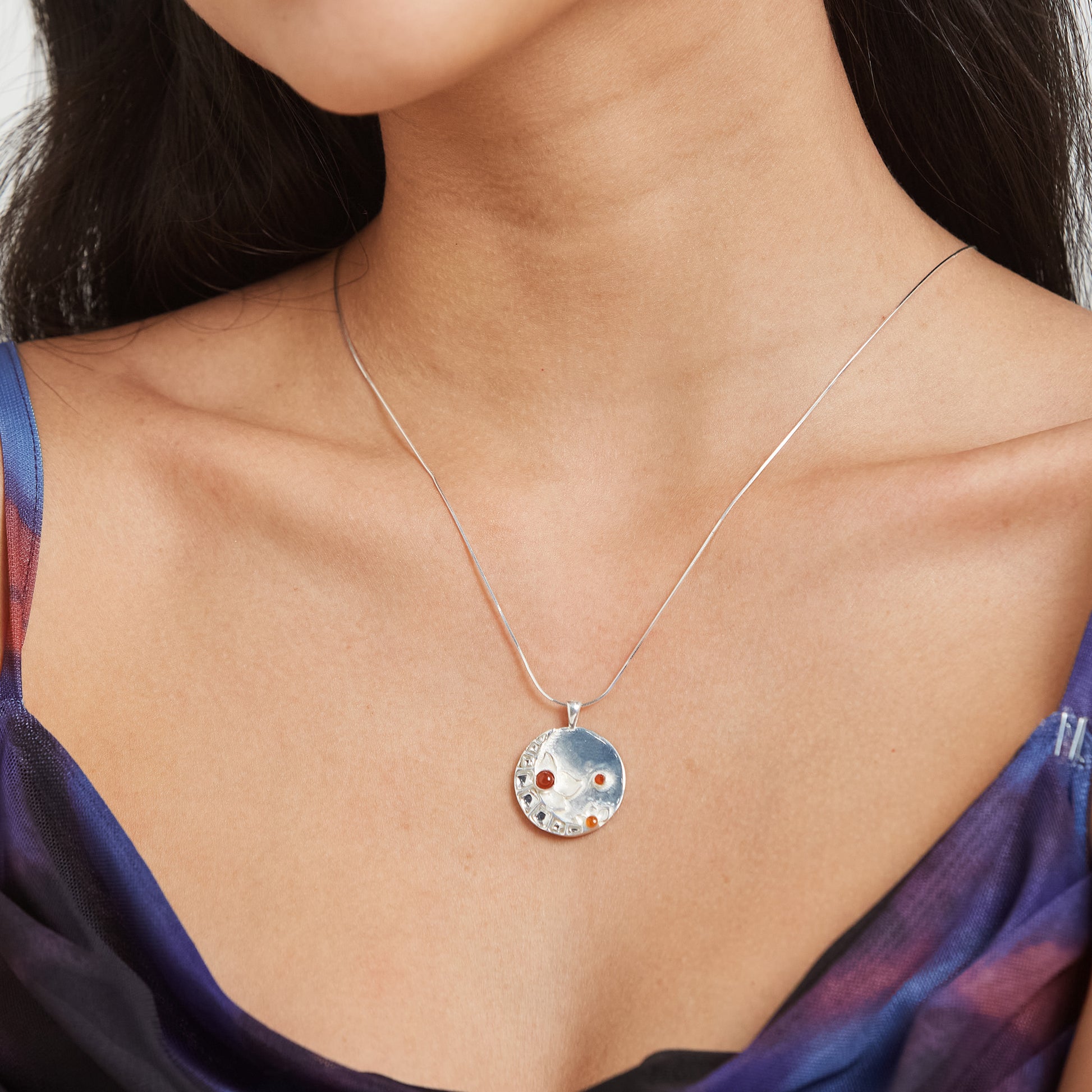 Detail shot of a model showcasing the craftsmanship of a sterling silver Full Moon necklace.