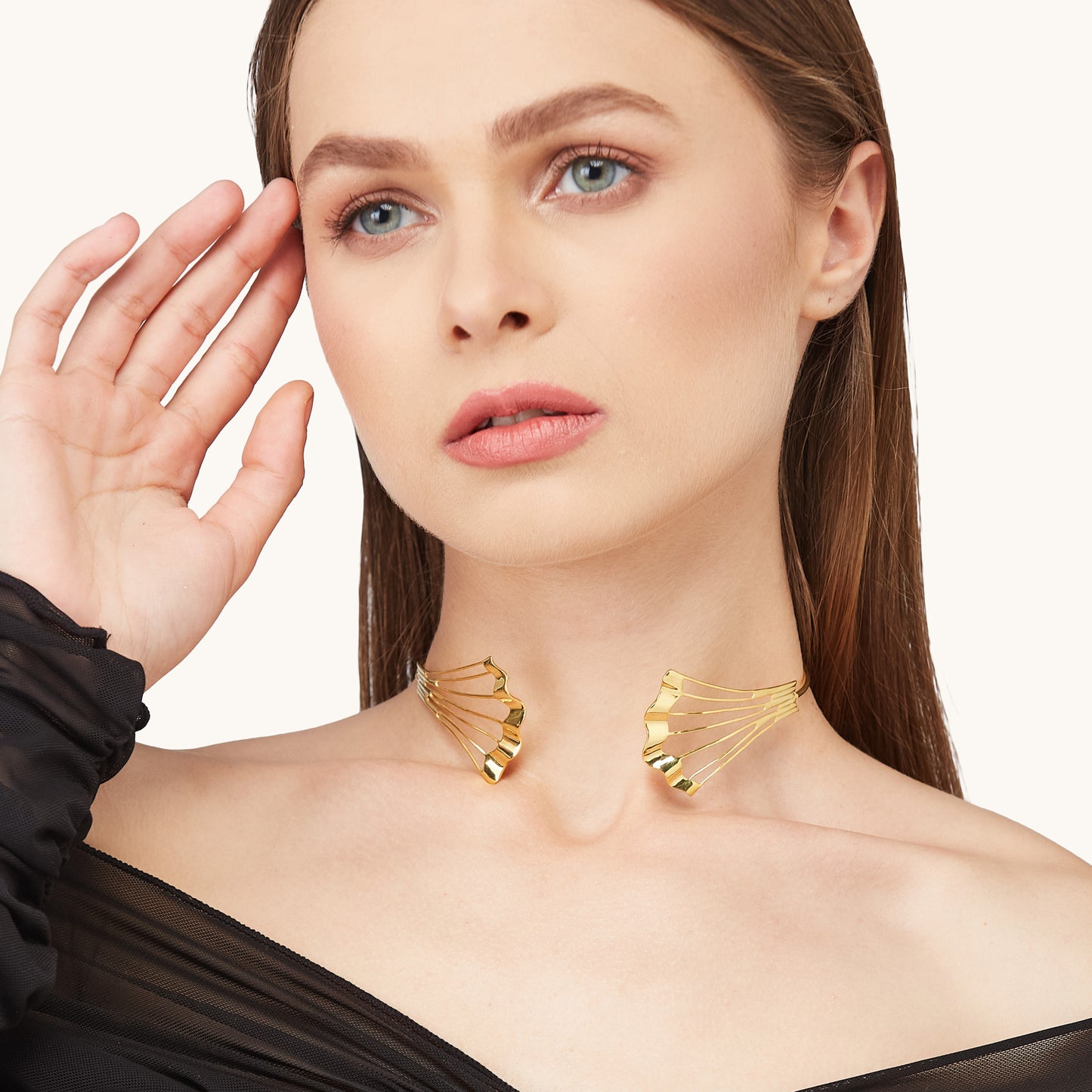 Editorial portrait of a model with slicked-back hair wearing the Gold Flow Necklet, styled with a black sheer outfit.