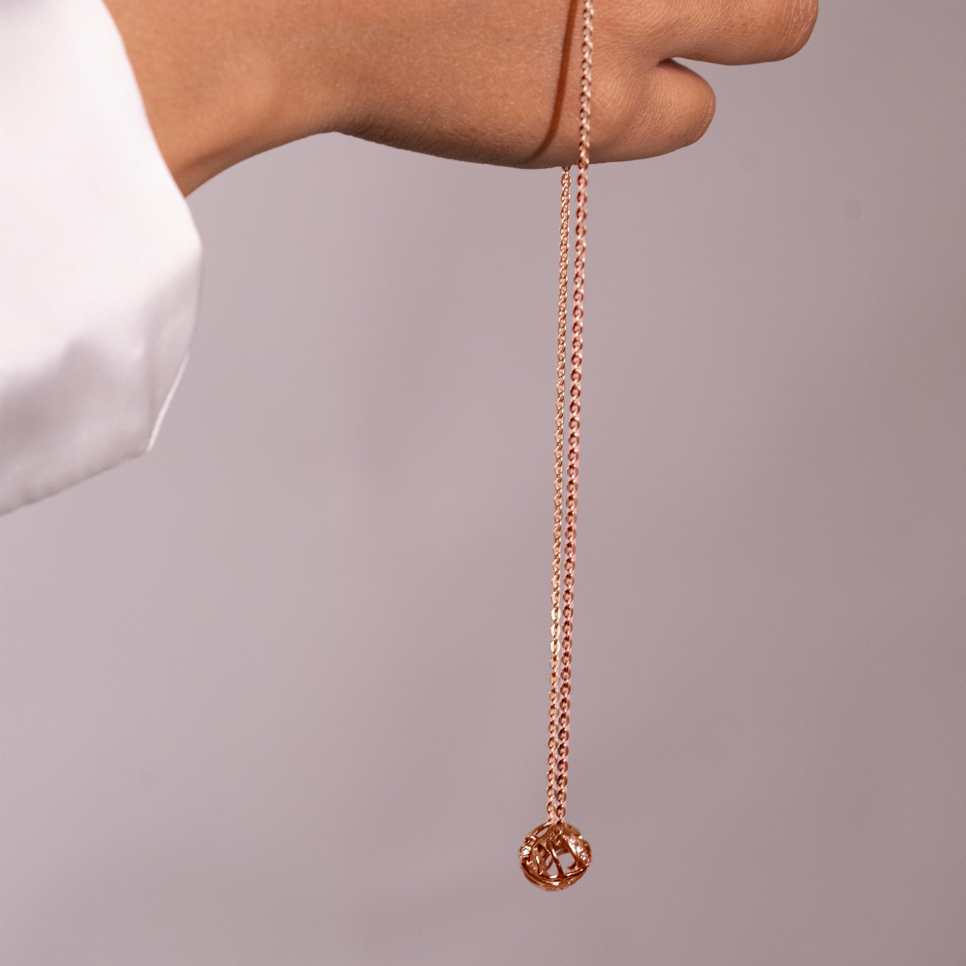 An angled view of a bold, wave-like metallic necklace, highlighting the unique, flowing contours of the piece.