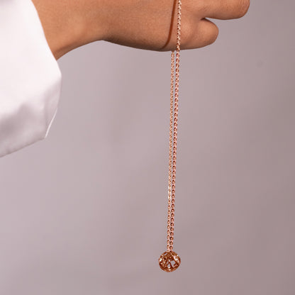 An angled view of a bold, wave-like metallic necklace, highlighting the unique, flowing contours of the piece.