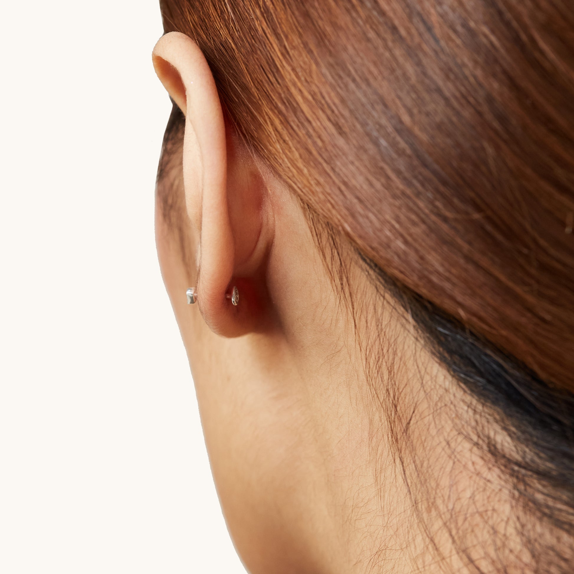 Minimalist geometric triangle studs with a smooth flat back to prevent poking behind the ear.