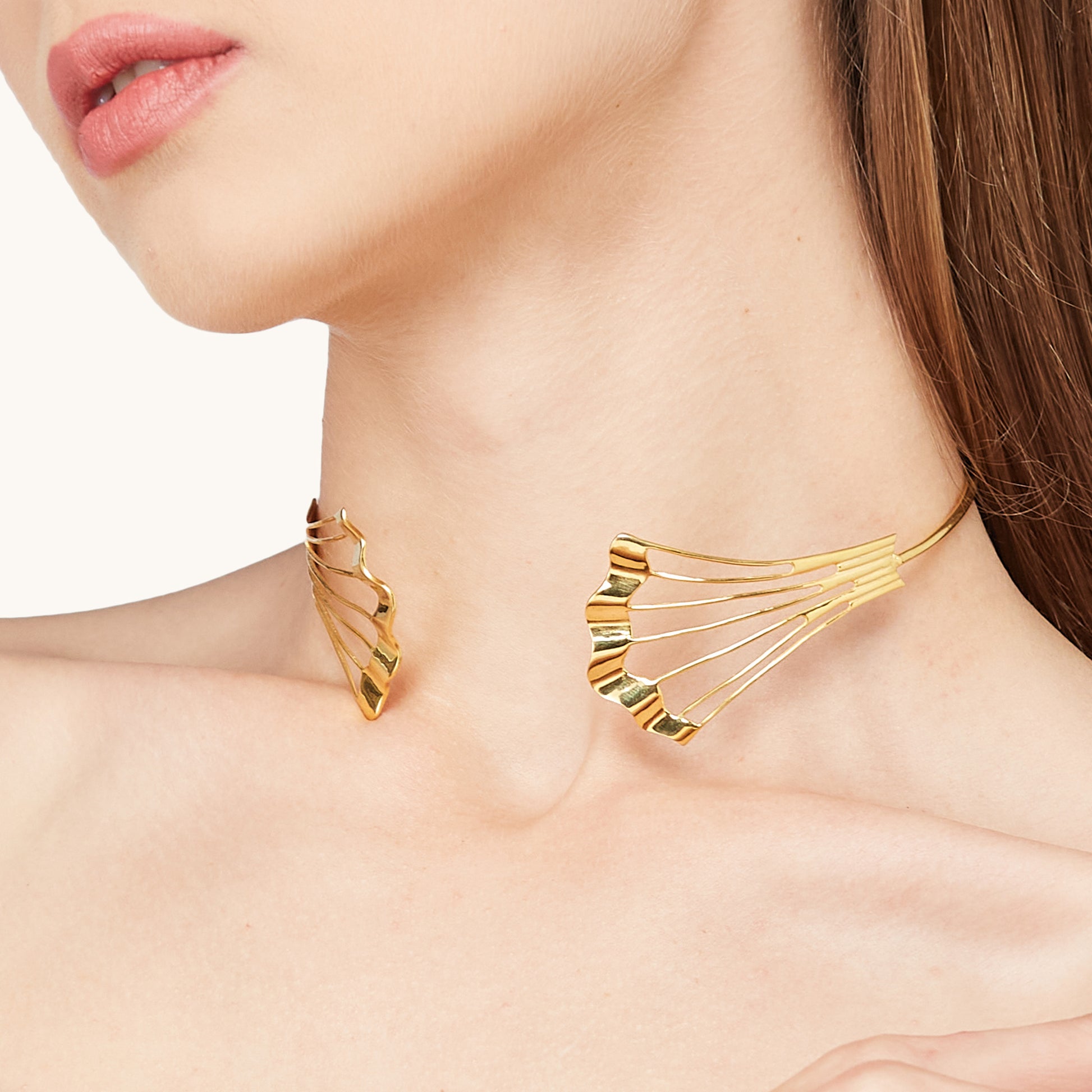 Macro shot of the Gold Flow Necklet on a model's neck, emphasizing the high-polish finish and intricate wire-work detail.