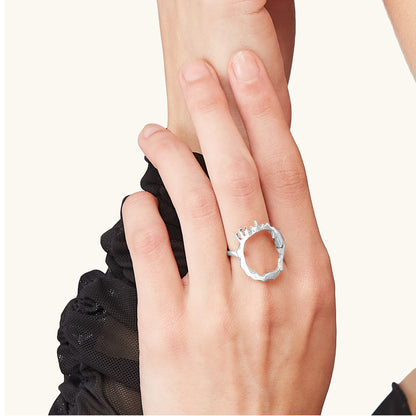 Close-up of a model's hand wearing the Silver Drip Ring, highlighting how the liquid metal design wraps around the finger.