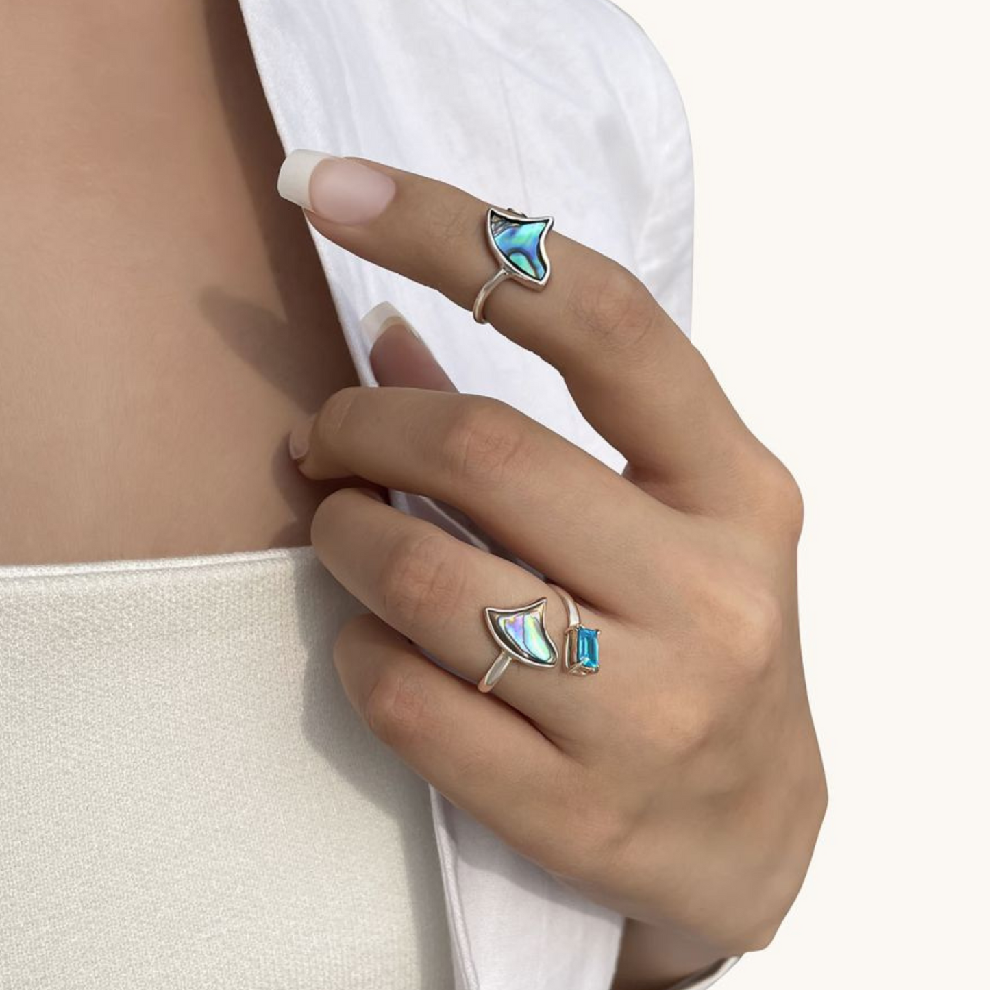 Close-up of a model wearing a contemporary sterling silver band, showcasing its minimalist, fluid silhouette and how it elegantly contours to the finger.