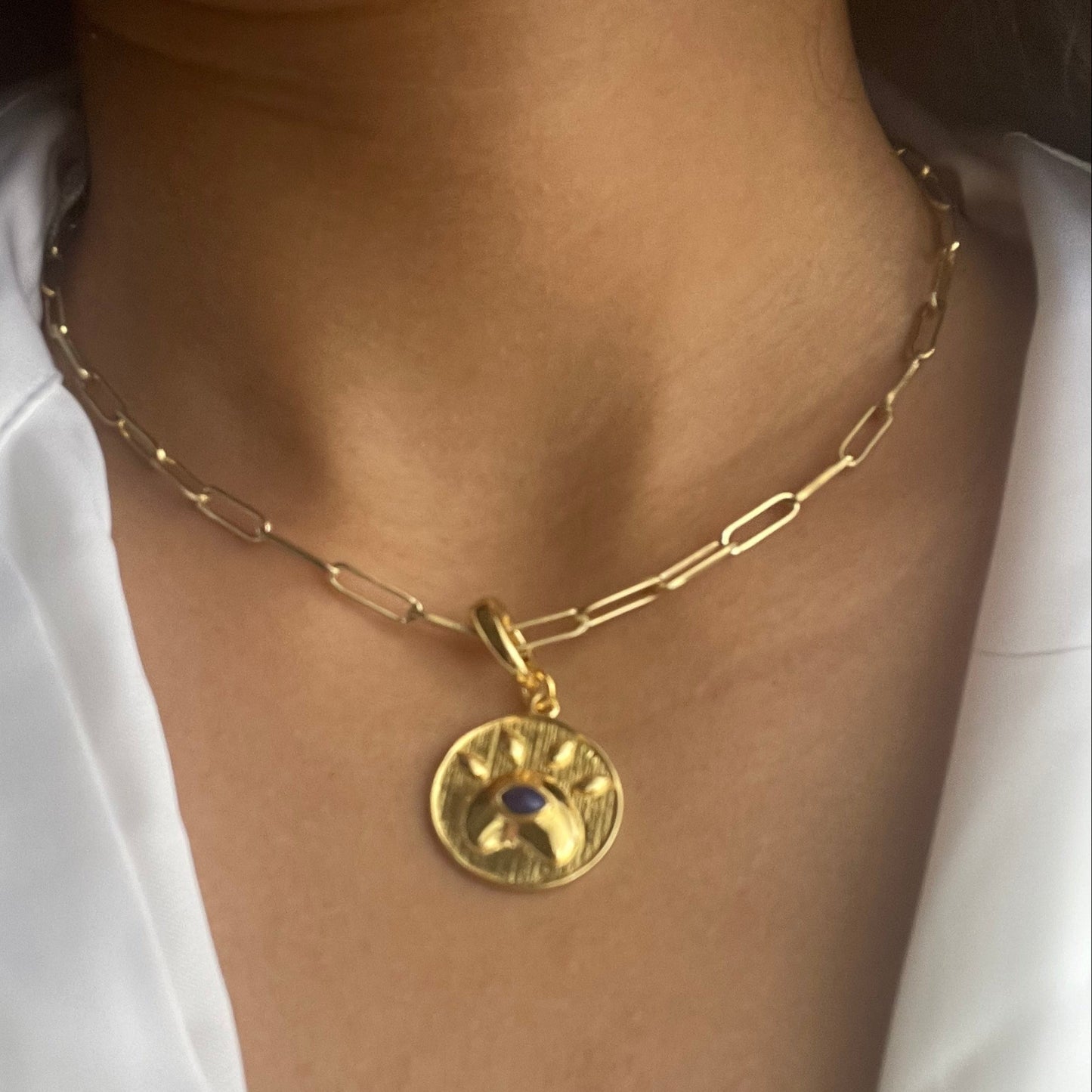 Model wearing a Lapis lazuli eye charm in gold-tone brass with lobster clasp closure.