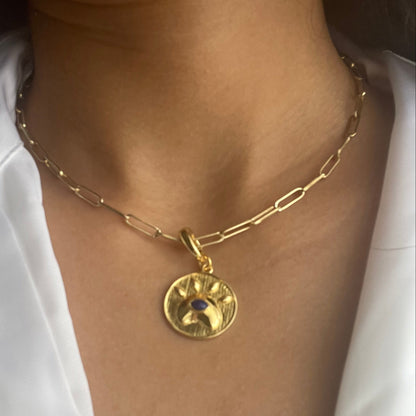 Model wearing a Lapis lazuli eye charm in gold-tone brass with lobster clasp closure.