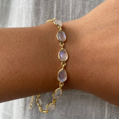 Wrist wearing an elegant, adjustable silver chain bracelet with a luminescent stone accent, styled for a minimalist look.