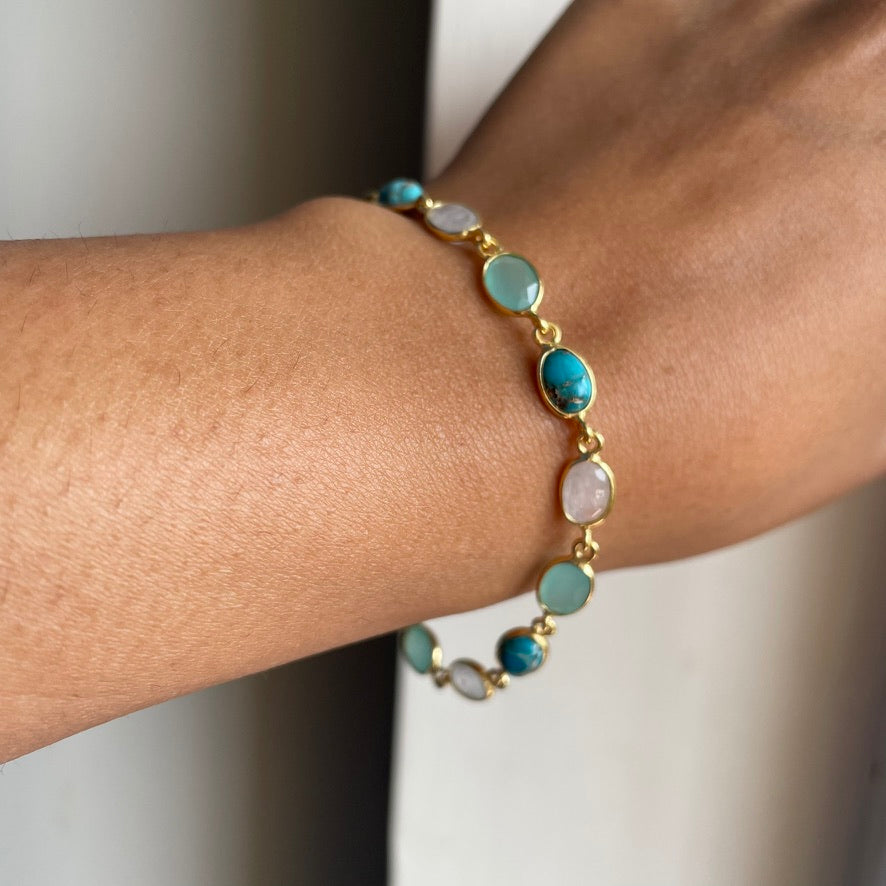 Wrist wearing an elegant, adjustable silver chain bracelet with vibrant blue stone accents, styled for a minimalist look.