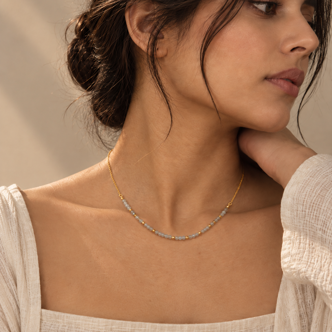 Calming Bead Necklace featuring round granite beads and tiny gold beads styled on a female model.