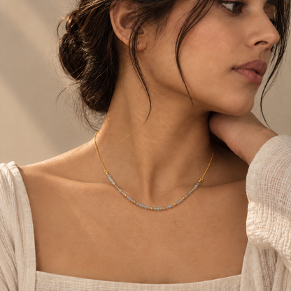 Calming Bead Necklace featuring round granite beads and tiny gold beads styled on a female model.
