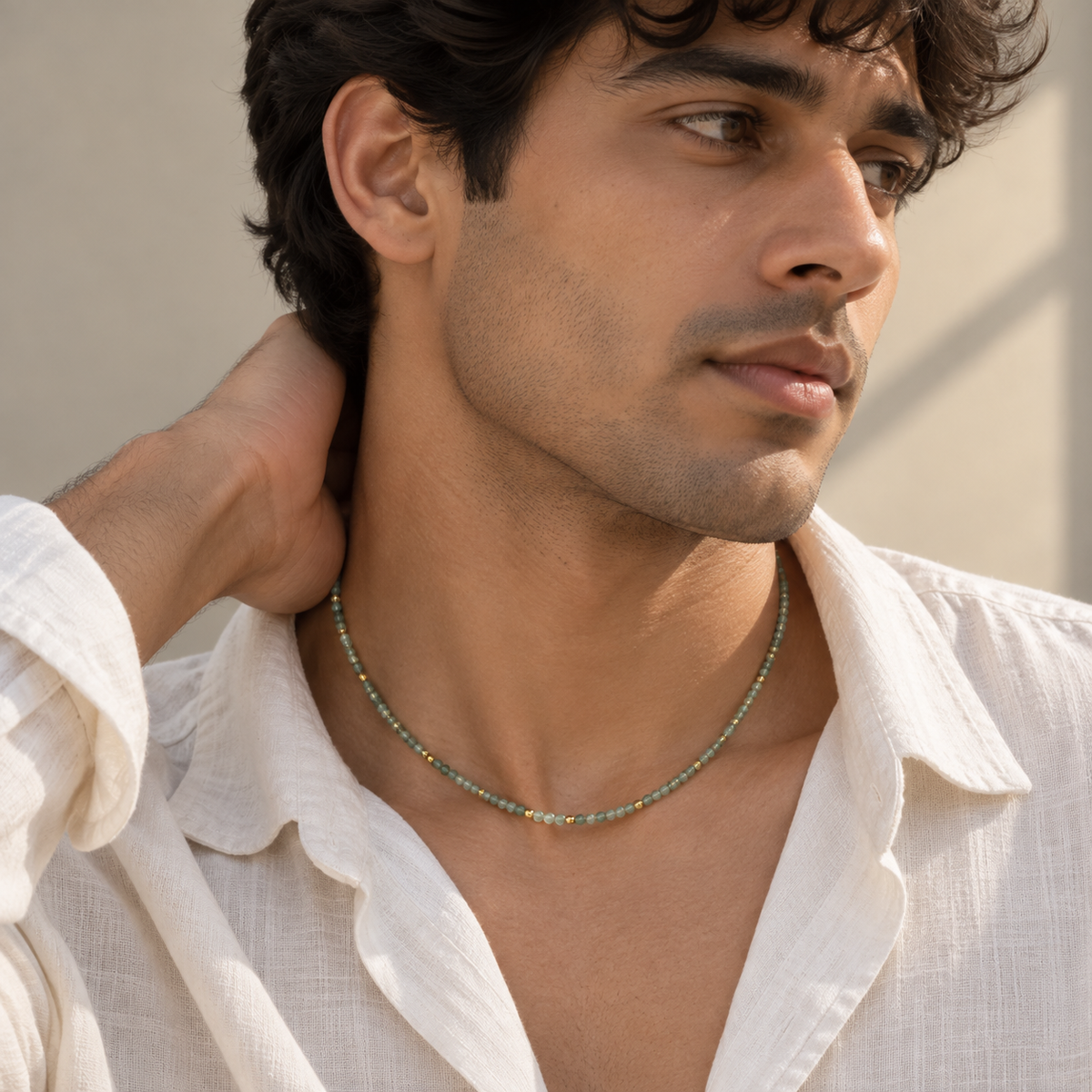 Meadow Necklace featuring green beryl, granite and labradorite beads with gold accents styled on a male model.