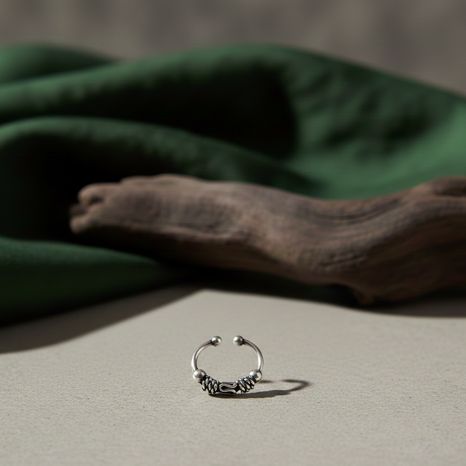 Oxidised 925 sterling silver boho nose ring for unpierced nose with intricate filigree work, handcrafted in India on a neutral backdrop.
