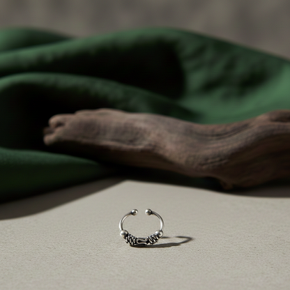 Oxidised 925 sterling silver boho nose ring for unpierced nose with intricate filigree work, handcrafted in India on a neutral backdrop.
