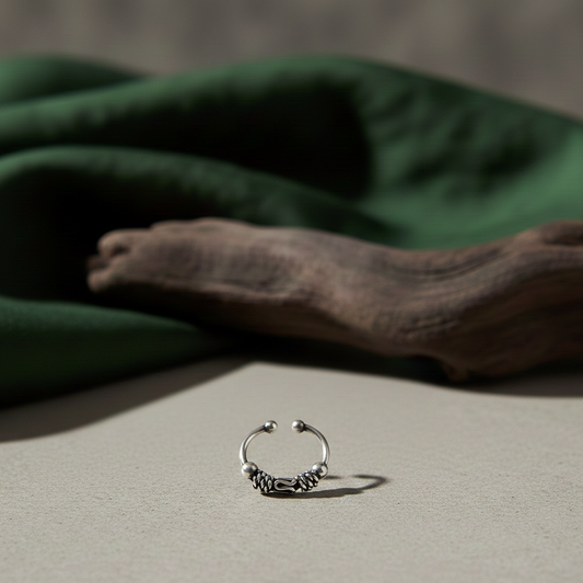 Oxidised 925 sterling silver boho nose ring for unpierced nose with intricate filigree work, handcrafted in India on a neutral backdrop.
