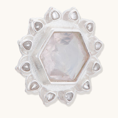 A close-up, angled view of a sterling silver stud earring featuring a pale pink hexagonal gemstone surrounded by a delicate lotus-inspired petal border.