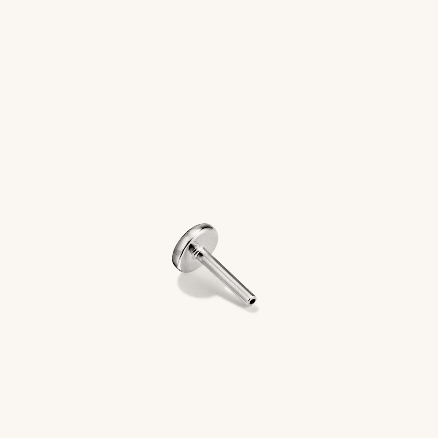 Rear view of a silver flat back stud earring showing the smooth circular post base.