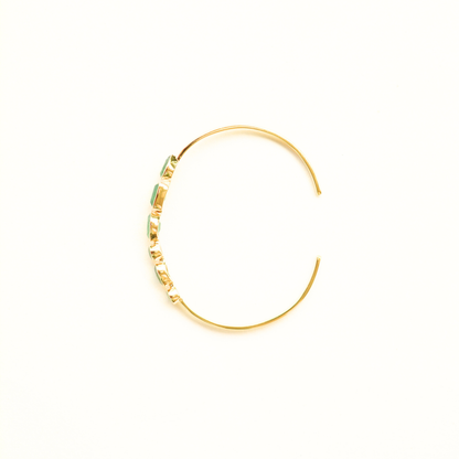 Top view of a gold-plated silver cuff bracelet highlighting the bezel-set green aventurine stones and its open-ended design.