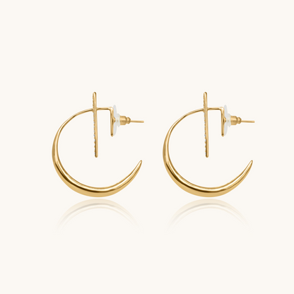 Celestial jewelry in yellow gold on a white background with a soft reflection, emphasizing the minimalist celestial jewelry design.