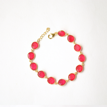 Top view of an adjustable silver bracelet with a delicate pink gemstone charm, highlighting the slider clasp.