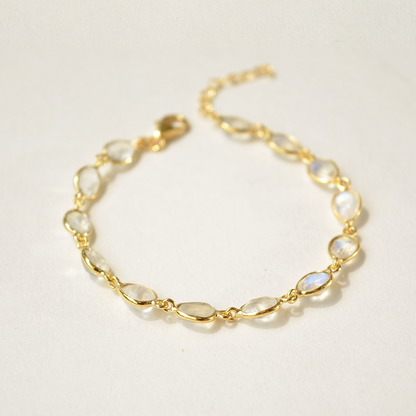 A delicate silver bracelet with a smooth, light-reflecting moonstone charm on a clean white background.