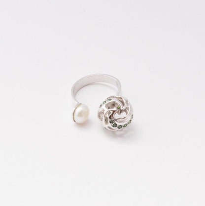 A sophisticated silver ring featuring a lustrous, high-quality pearl that rests gracefully on a sleek, polished band, isolated on a white background.