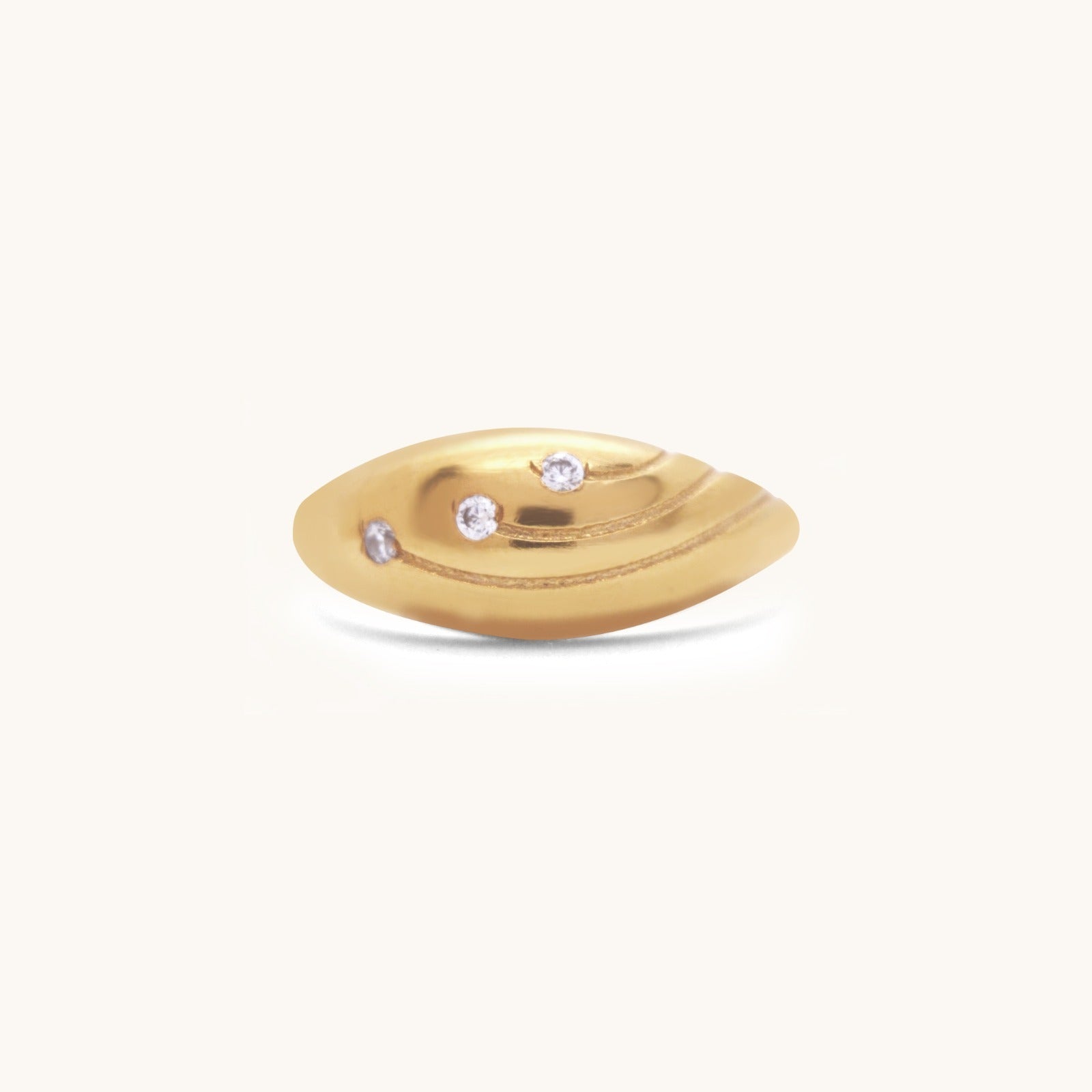 Front view of a gold dome ring showcasing its smooth, rounded design and three flush-set gemstones.
