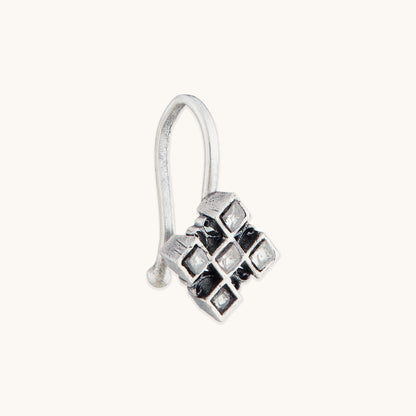 An angled view of a silver-toned, non-piercing nose ring showcasing a geometric, multi-square metal design with inset reflective stones.