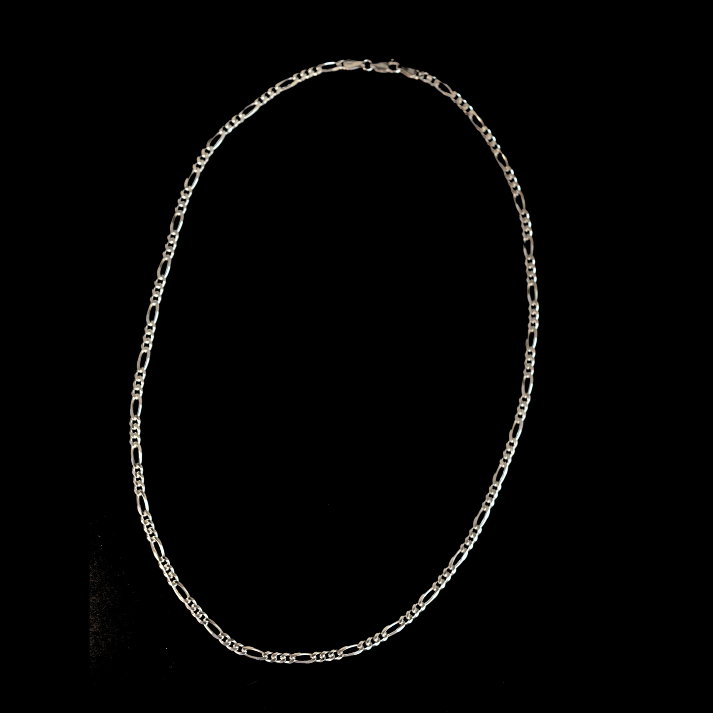 A minimalist, polished silver circular chain featuring a sleek, modern aesthetic suitable for all genders, isolated on a black background